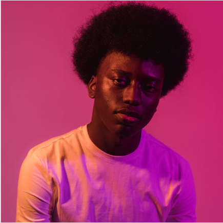 A data analytics creator portrait lit in magenta and purple.